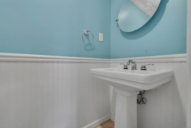 bathroom featuring a wainscoted wall and a sink