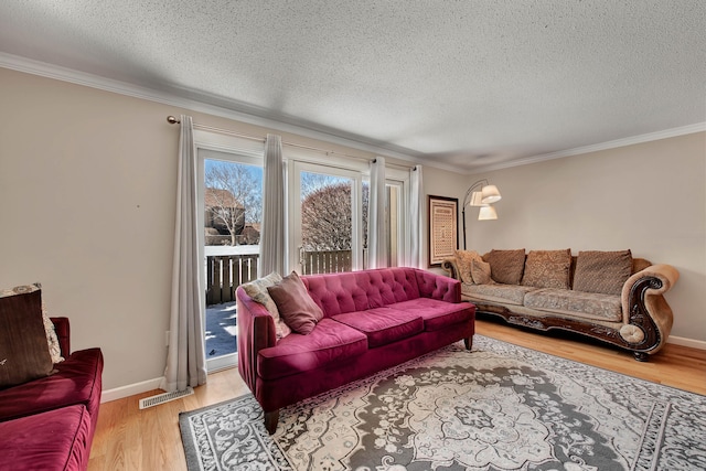 living area featuring baseboards, a textured ceiling, light wood-style flooring, and crown molding