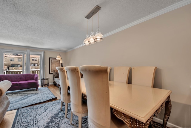 dining area with a textured ceiling, baseboards, wood finished floors, and crown molding