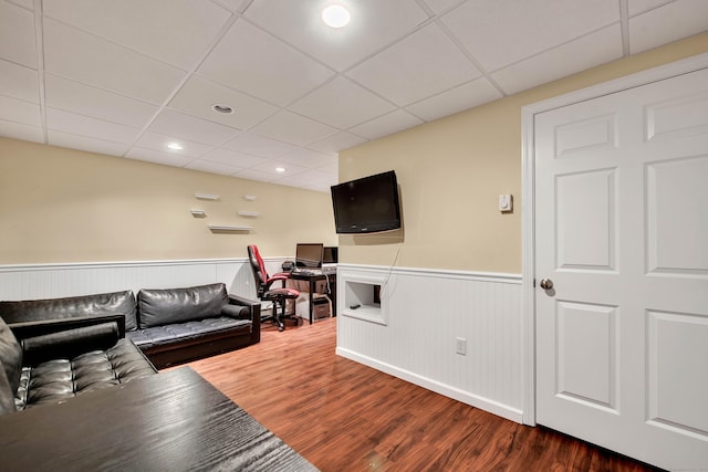 living room featuring a paneled ceiling, dark wood-style flooring, a wainscoted wall, and recessed lighting