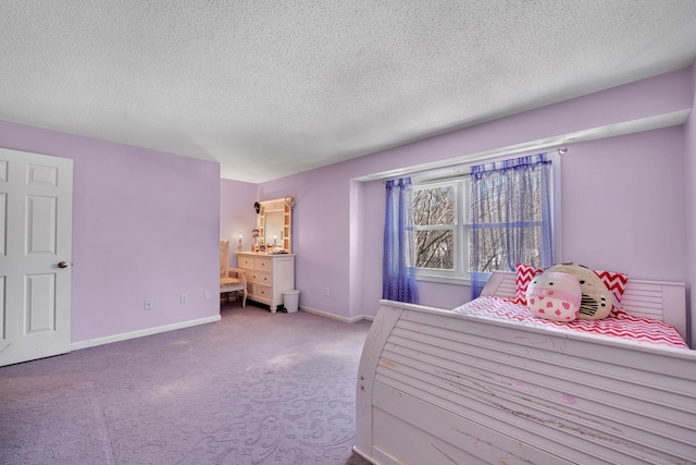 bedroom with light carpet, a textured ceiling, and baseboards