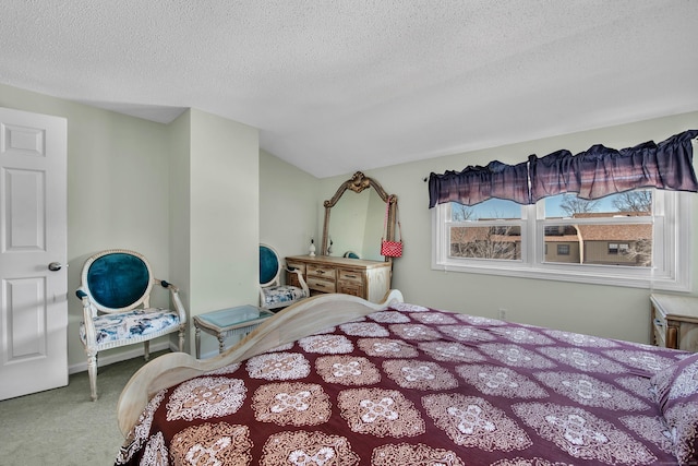 bedroom with lofted ceiling, a textured ceiling, and carpet flooring