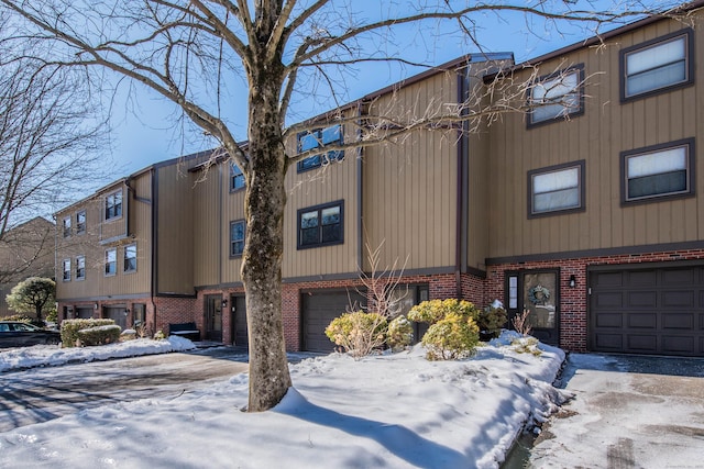 multi unit property featuring a garage and brick siding