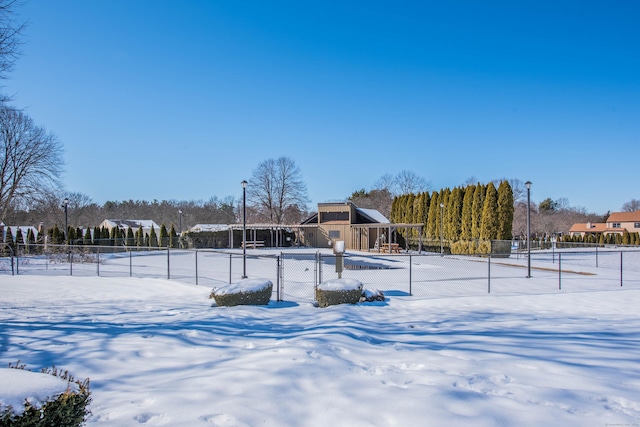 snowy yard with a residential view and fence