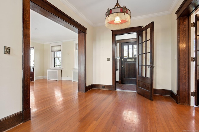 entrance foyer featuring crown molding, baseboards, and wood-type flooring