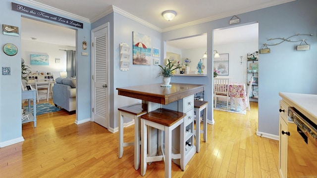 dining area featuring crown molding and light hardwood / wood-style flooring