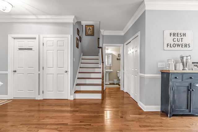 foyer entrance featuring hardwood / wood-style flooring and crown molding