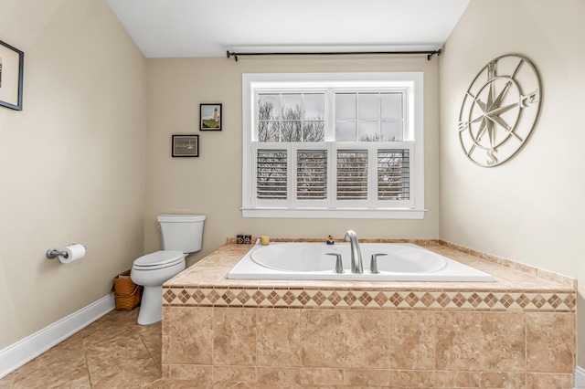 bathroom with tile patterned flooring, toilet, and tiled tub