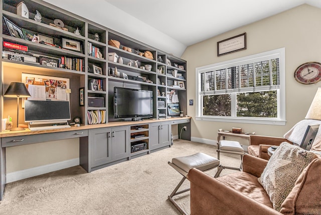 carpeted home office featuring built in desk and lofted ceiling