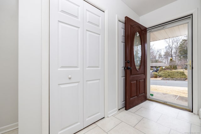 foyer entrance featuring baseboards and light tile patterned floors