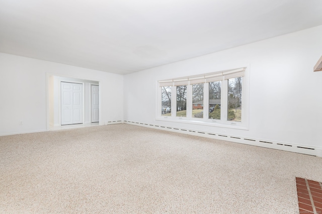 unfurnished room featuring baseboard heating and carpet