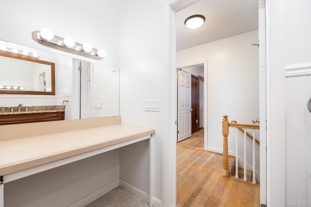 bathroom featuring wood finished floors, vanity, and baseboards