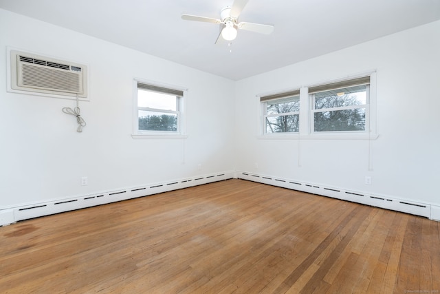 empty room featuring plenty of natural light, wood-type flooring, ceiling fan, and a wall mounted air conditioner