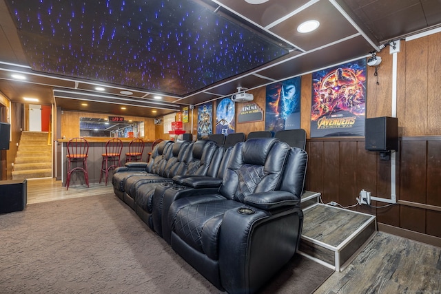 cinema with recessed lighting, wood walls, a dry bar, and wood finished floors