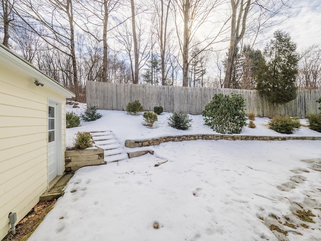 yard covered in snow featuring fence