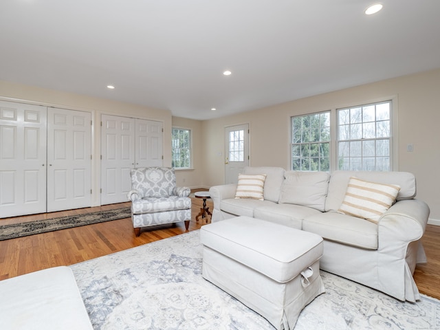 living area with baseboards, wood finished floors, and recessed lighting