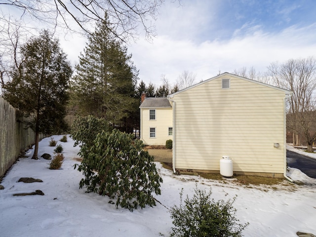 view of snowy exterior with fence