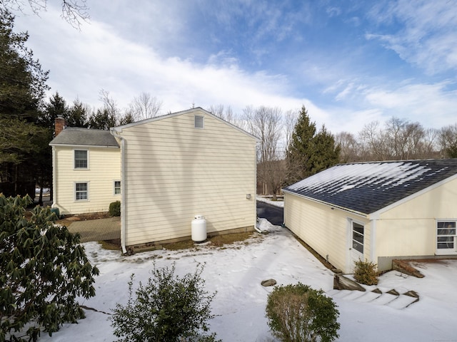 snow covered property with a chimney