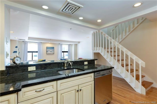 kitchen with visible vents, light wood-style flooring, a sink, cream cabinetry, and stainless steel dishwasher