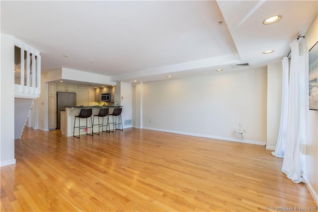 unfurnished living room featuring visible vents, recessed lighting, light wood-type flooring, and baseboards