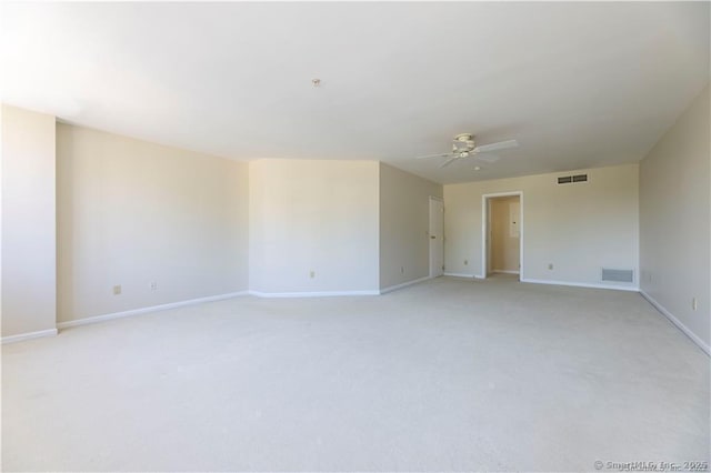 unfurnished room featuring baseboards, light colored carpet, visible vents, and ceiling fan