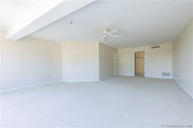 unfurnished room with light carpet, visible vents, baseboards, and ceiling fan