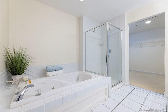 bathroom featuring tile patterned floors, a spacious closet, a stall shower, and a whirlpool tub