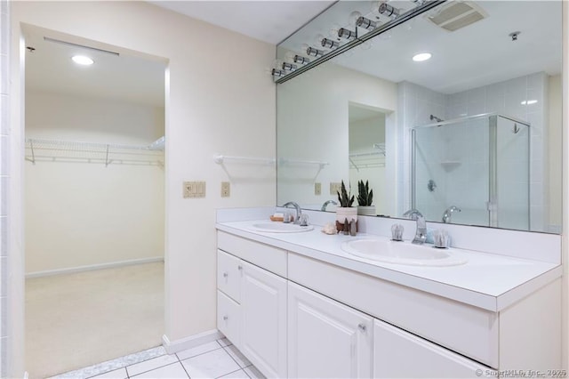 full bathroom featuring tile patterned floors, a shower stall, double vanity, and a sink