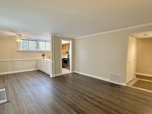 unfurnished living room featuring dark wood-style floors, visible vents, ornamental molding, and baseboards