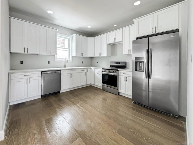 kitchen featuring dark hardwood / wood-style flooring, sink, stainless steel appliances, and white cabinets