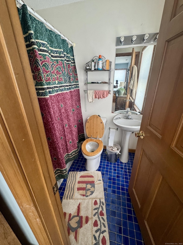 bathroom featuring sink, toilet, and tile patterned floors