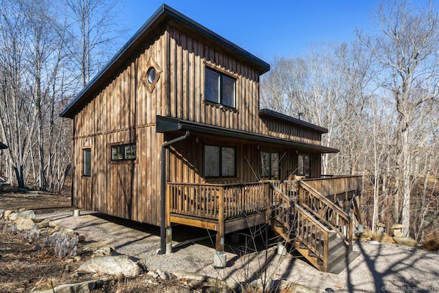 rear view of house with board and batten siding and a wooden deck