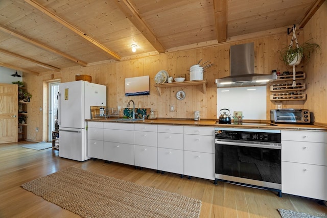 kitchen with freestanding refrigerator, oven, range hood, black electric cooktop, and a sink