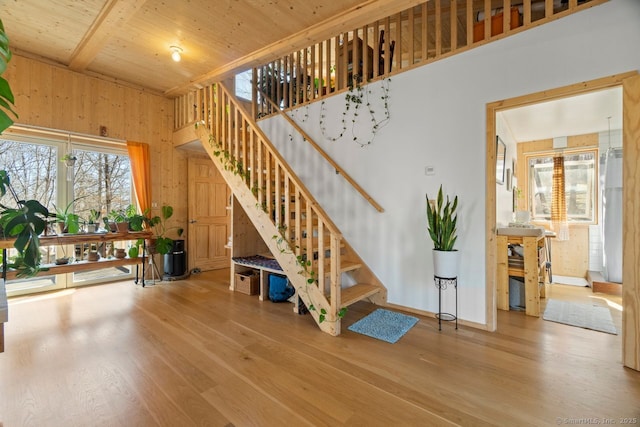 stairway featuring wood walls, baseboards, and wood finished floors