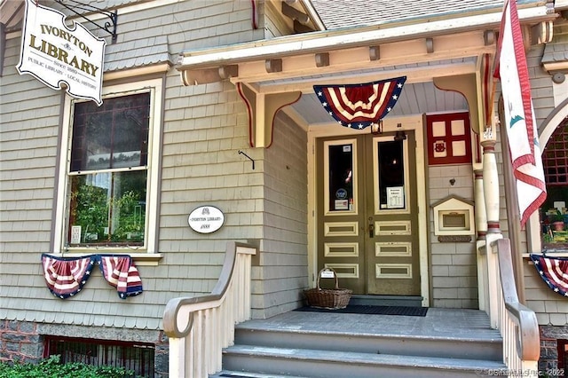 entrance to property with roof with shingles