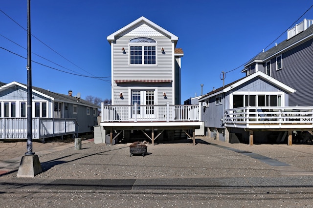 view of front of house with a fire pit and a deck