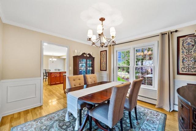 dining space featuring a chandelier, light wood finished floors, and crown molding