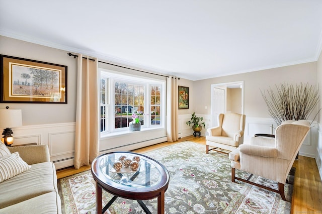 living area featuring ornamental molding, wainscoting, wood finished floors, and a baseboard radiator