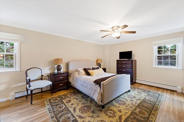 bedroom with a baseboard heating unit, multiple windows, and light wood finished floors