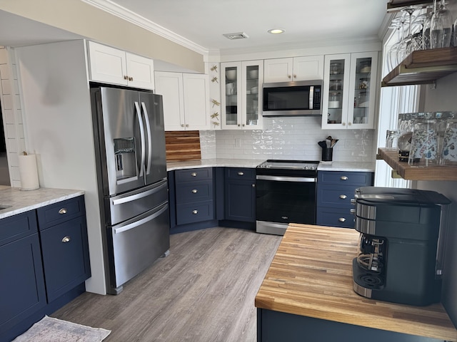 kitchen with appliances with stainless steel finishes, blue cabinets, and white cabinetry