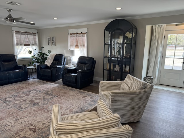 living room featuring hardwood / wood-style flooring, ceiling fan, and ornamental molding