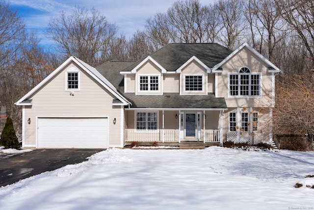 traditional home featuring a garage, aphalt driveway, covered porch, and a shingled roof