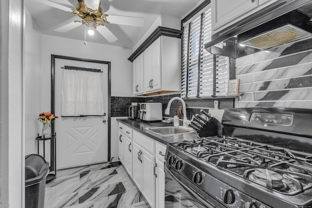 kitchen featuring gas stove, sink, premium range hood, white cabinetry, and decorative backsplash