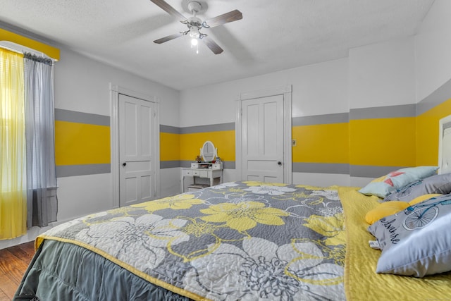 bedroom with hardwood / wood-style flooring, ceiling fan, and a textured ceiling