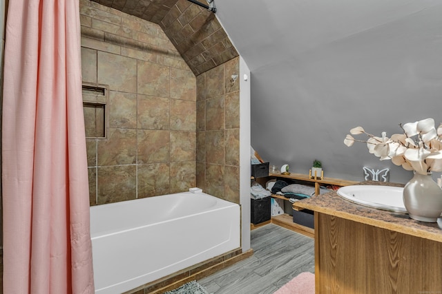 bathroom with hardwood / wood-style floors, shower / bath combo, vaulted ceiling, and vanity