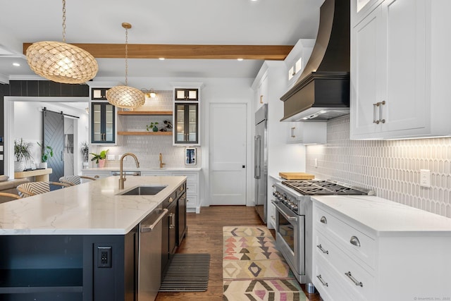 kitchen featuring open shelves, premium range hood, a barn door, high end appliances, and a sink