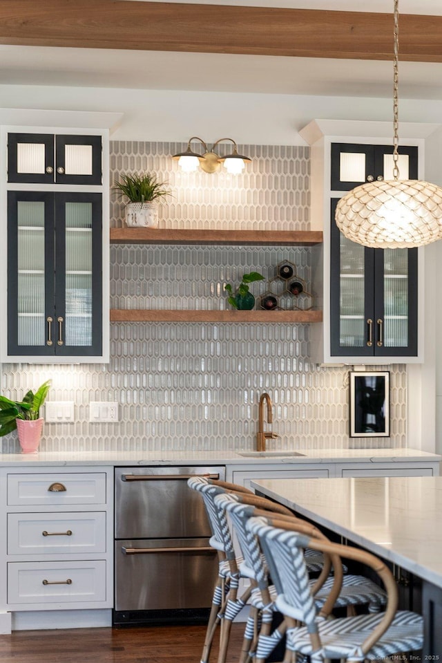 bar with pendant lighting, a sink, backsplash, dishwasher, and dark wood-style flooring