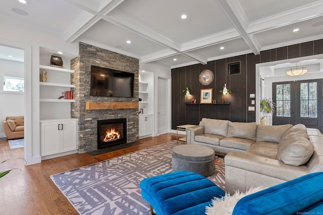 living area with built in features, wood finished floors, coffered ceiling, beam ceiling, and french doors