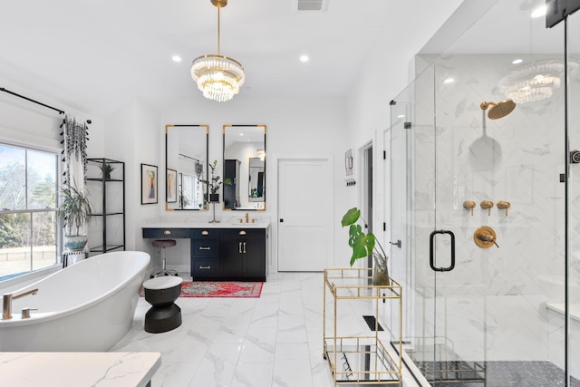 bathroom featuring marble finish floor, an inviting chandelier, a shower stall, a freestanding bath, and vanity