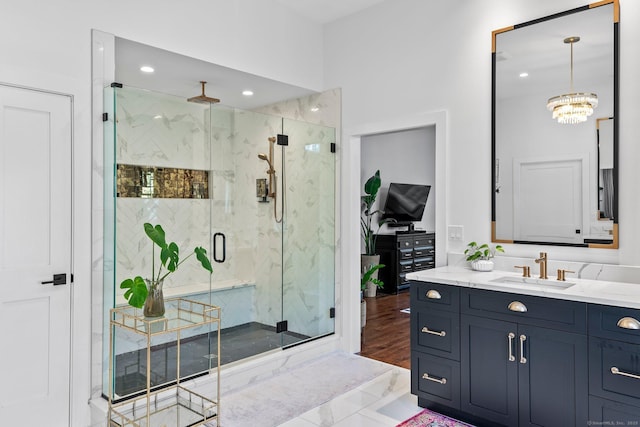 full bath featuring recessed lighting, a marble finish shower, an inviting chandelier, and vanity